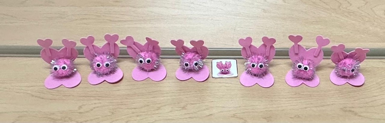 A row of pink paper butterflies with heart wings — a KSW classroom art activity